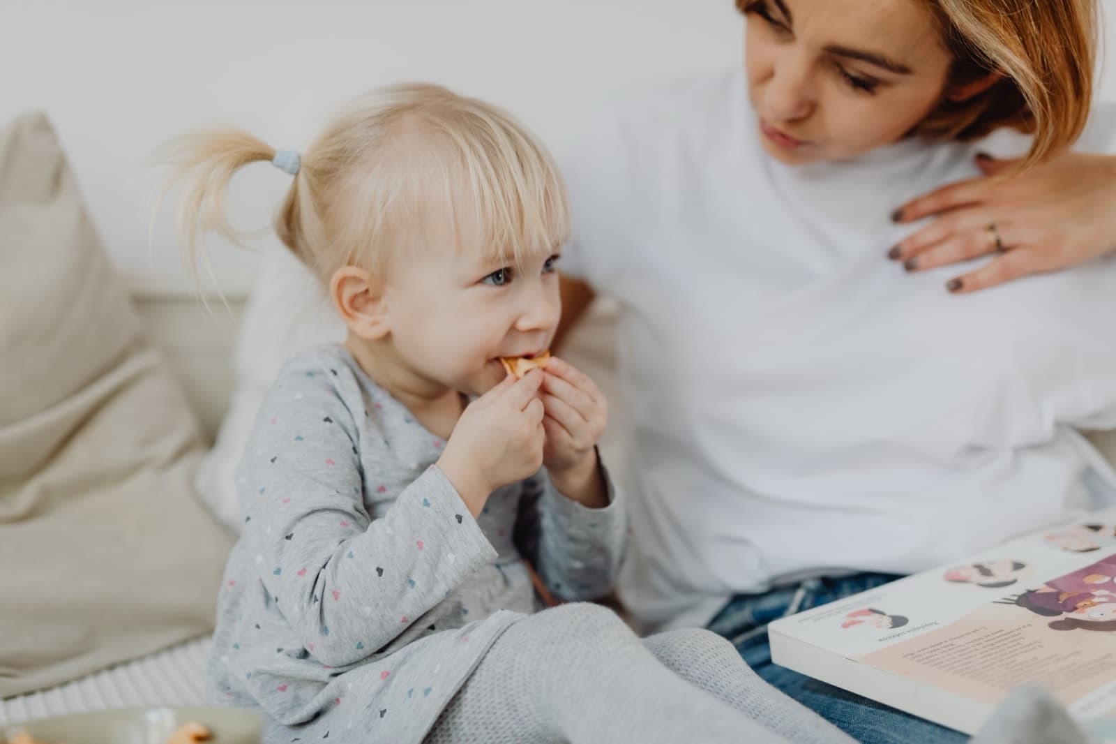 Mama i ćerka se druže kod kuće dok bebisiterka pomaže porodici